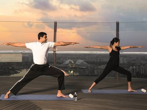 在 Skypark 公共觀景台進行悅榕健身俱樂部日出瑜珈練習
